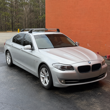 BMW 5 Series Sedan F10 2010-2017 black roof rack cross bars fitted to factory fixed mounting points