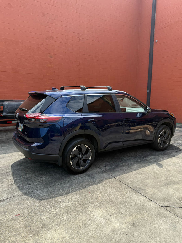 Blue SUV parked on a concrete surface with a red wall in the background