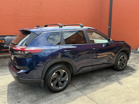 Blue SUV parked in front of a red brick wall