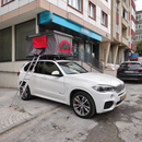 Roof rack cross bars supporting rooftop tent and camping gear